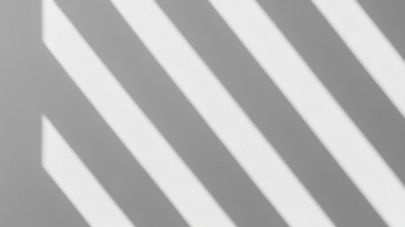 A minimalist image featuring diagonal shadows cast on a gray surface, creating a striking interplay of light and dark.の素材