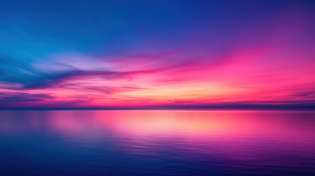 Serene Sunset Over Calm Water with Vibrant Pink and Purple Sky Reflections Creating a Tranquil Landscape at Dusk in a Coastal Environmentの素材