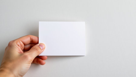 hand placing a blank tent card mockup on light background, position subject on the left with copy space on the right for photos.の素材