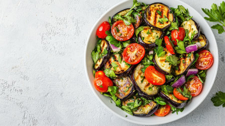 A vibrant bowl of grilled vegetables, including eggplant, tomatoes, and herbs, showcasing a healthy, colorful salad.の素材