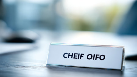 Professional nameplate for a business executive displaying the name "CHEIF OIFO" on a modern office desk in bright, soft-focus workspace backgroundの素材