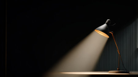 Elegant Desk Lamp Casting Soft Light in Minimalist Workspace with Dark Background and Subtle Textures Understated Modern Design Aestheticの素材