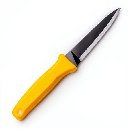 Sharp black kitchen knife with yellow plastic handle isolated on white background, perfect for food preparation, culinary tasks, and cooking demonstrations.の素材