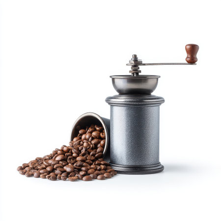 Vintage coffee grinder with freshly roasted coffee beans spilling out on white background, perfect for coffee lovers and culinary enthusiastsの素材