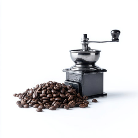 Vintage coffee grinder with heap of roasted coffee beans on white background showcasing the art of coffee preparation and the rich aroma of fresh coffee-makingの素材