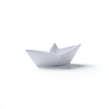 Simple White Paper Boat on a Clean Surface, Representing Childhood Memories and Creativity in a Minimalist Style for Artistic Projects and Educational Usesの素材