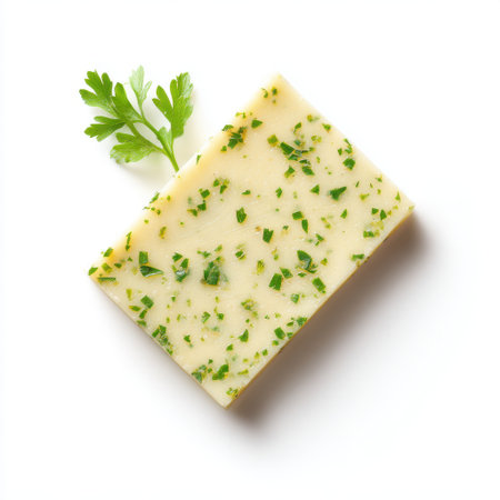 Fresh herb butter block with bright green parsley pieces on a clean white background, perfect for culinary presentations and gourmet recipes.の素材