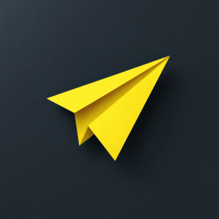 Yellow paper airplane on a dark background, symbolizing creativity, innovation, and the joy of flight in a minimalist design aestheticの素材