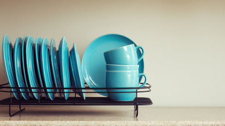 Bright Turquoise Plates and Cups on Dish Rack Displayed on Kitchen Countertop Against Neutral Background for Modern Dining Decorの素材