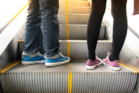 Close up Men wear jeans and woman on escalator to upの写真素材