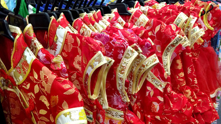 Red Cheongsam (qipao) dress for girl on hangersの写真素材