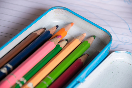 Close up crayon in box on noteの写真素材