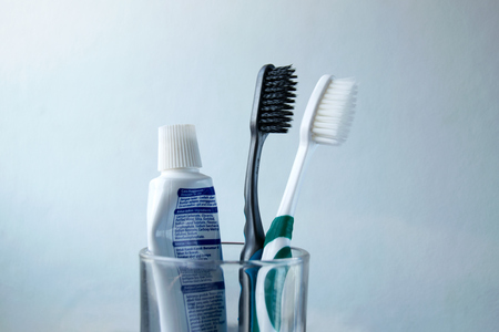 Black and white Toothbrush and toothpaste in glassの写真素材