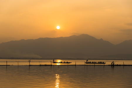 landscape view - boatman paddle boat  in the lagoon lake.(Kwan phayao) in evenign time at phayao thailandの写真素材