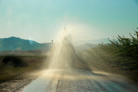 Workers on Water Truck are spraying water on the road to keep dust out.の写真素材