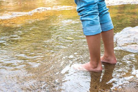 Close up leg Women's Jeans Stand on the stream river