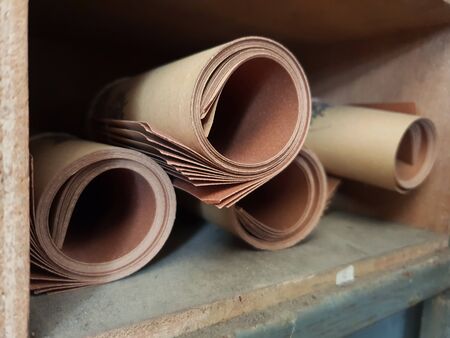 stack of rolled Abrasive paper in brown colour on a shelfの写真素材