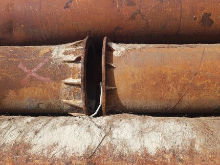 closeup old rusty metal pipes abandoned with red crossed spay onの写真素材