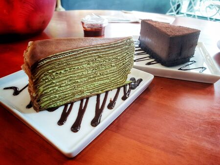 matcha green tea and chocolate crepe cake on a plateの写真素材