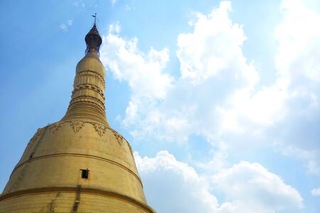 Myanmar golden statue pagoda isolated on blue sky backgroundの写真素材