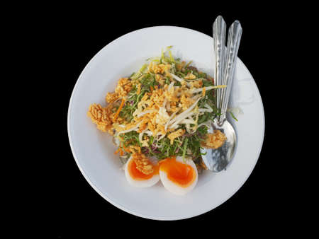 Khao Yum Rice with mixed herb vegetables Thai local southern style dish alongwith boiled eggs ready to eat isolated on black backgroundの写真素材
