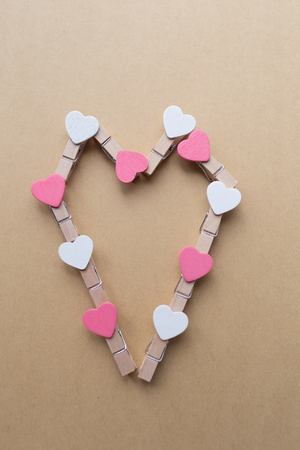 Clothespins with hearts on Notepad. Background is blue paperの写真素材