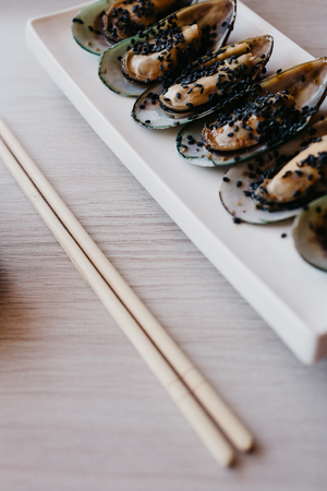 Shrimp mussels and squid on frying pan close up with garlic and cutleryの写真素材