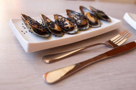 Shrimp mussels and squid on frying pan close up with garlic and cutlery