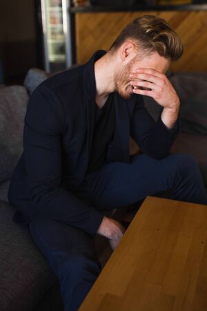 successful beautiful young man blond is located in a modern loft room, hookahの写真素材