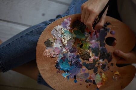 A palette of paints in the hands of a girl.の写真素材
