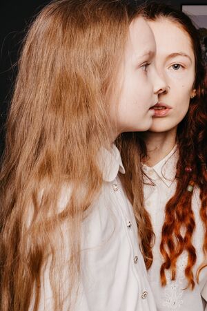 Portrait of the younger and older sisters in white shirts