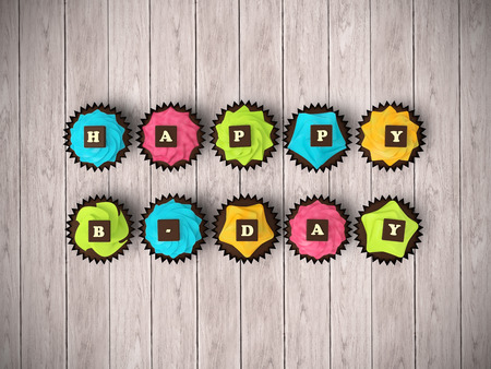 Happy Birthday cupcakes - top view render illustration of colorful muffins with cream and chocolate letters clipping path on bright hardwood backgroundの写真素材