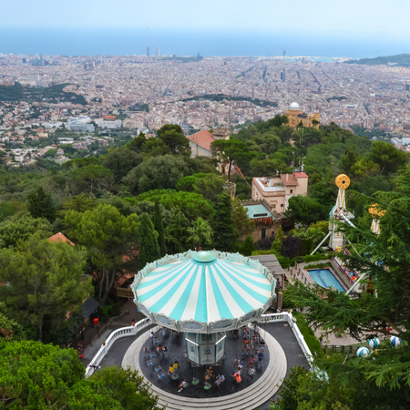 Carousel witch tourquise roof in the trees with city view of Barcelonaのeditorial素材