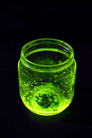 Open green light glowing jar on the dark backgroundの写真素材