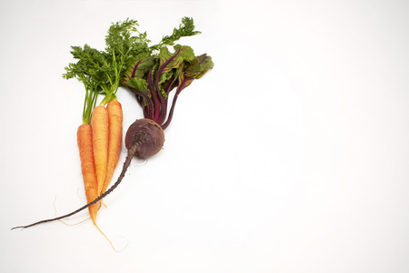 Fresh and juicy carrots and beetroot on white background, selective focus