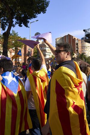 BARCELONA, SPAIN - 11 SEPTEMBER 2015: People waering Catalan flag at the day of Catalonia. Like a Hero in good direction.のeditorial素材
