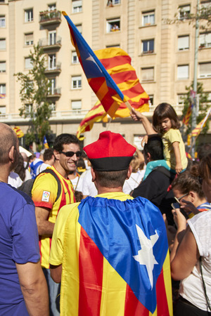 BARCELONA, SPAIN - 11 SEPTEMBER 2015: Crowd of people at the day of Catalonia, in front guy in traditional hat with flag.のeditorial素材