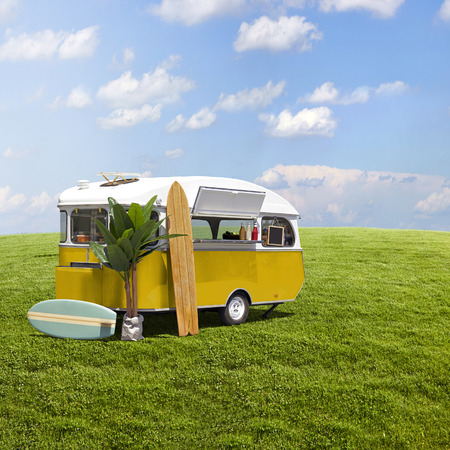 Yellow fast food truck caravan on green grass field backgroundの写真素材