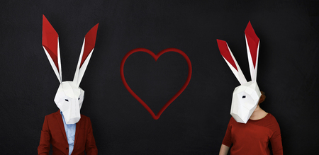 Happy valentines rabbits love story against blackboard background and heart shape.の写真素材
