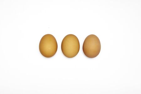 Three of browsn eggs on white background in the horizontal rowの写真素材