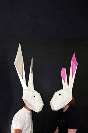 Happy Easter Rabbits couple in geometric masks on blackboard backgroundの写真素材
