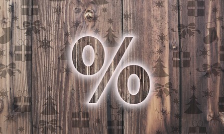 festive wooden percent symbol on wood with burned in christmas symbols such as snowflakes presents...