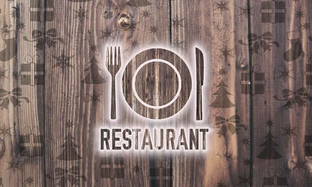 decorative wooden restaurant symbol on wood with burned in christmas symbols such as snowflakes presents and starsの写真素材