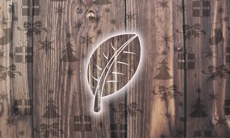 festive wooden leave label on wood with burned in christmas symbols such as snowflakes presents and starsの写真素材