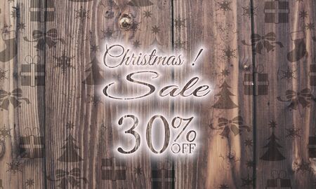 decorative wooden Christmas discount 30 percent off label on wood with burned in christmas symbols such as snowflakes presents and starsの写真素材