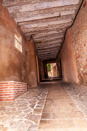 Inner village road with archway passage in touristic village of Miravet, Spainの写真素材