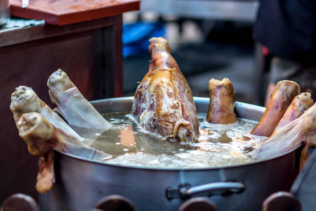 Cooking pork thighs in a giant pot During outdoor food market to. It is a very representative food of the medieval age and very typical for medieval fairsの写真素材