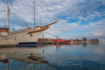 Dramatic partly cloudy sky reflecting over the calm waters of the port of Serrallo, Tarragona....