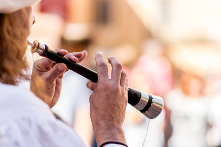 Flautist playing in medieval traditional music group  during medieval market in the town of Montblanc, Tarragona. Spain. Thanks to his music one can feel the atmosphere of a typical medieval market and travel in time, because the flaute was tipically asocの写真素材