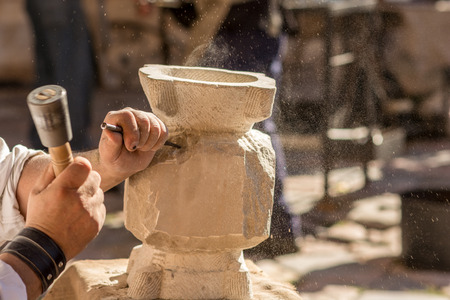 Marble master molding a piece of marble at a medieval fair in Tarragona, Spain. The pieces of marble are somewhat difficult to sell Given Their weight but there are lovers of art esta looking for works of marble Especially for decorationの写真素材